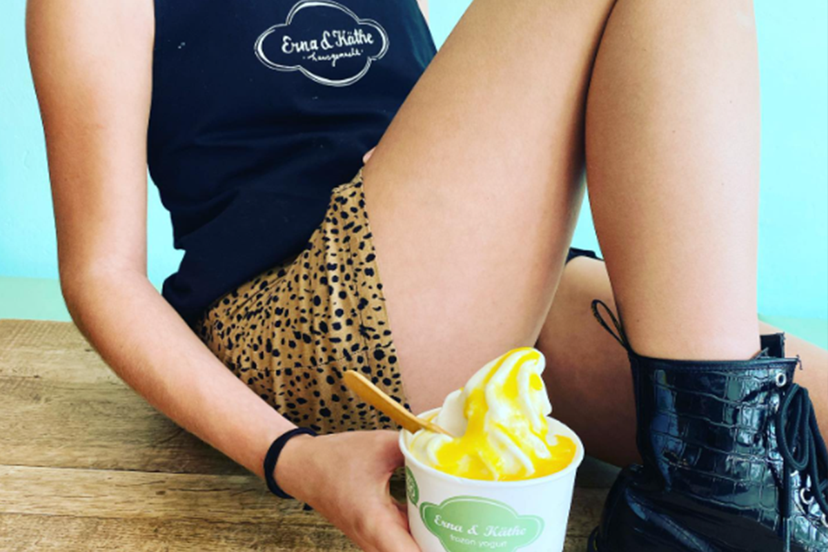 Erna & Käthe staff with branded apron and frozen yogurt cup with logo.